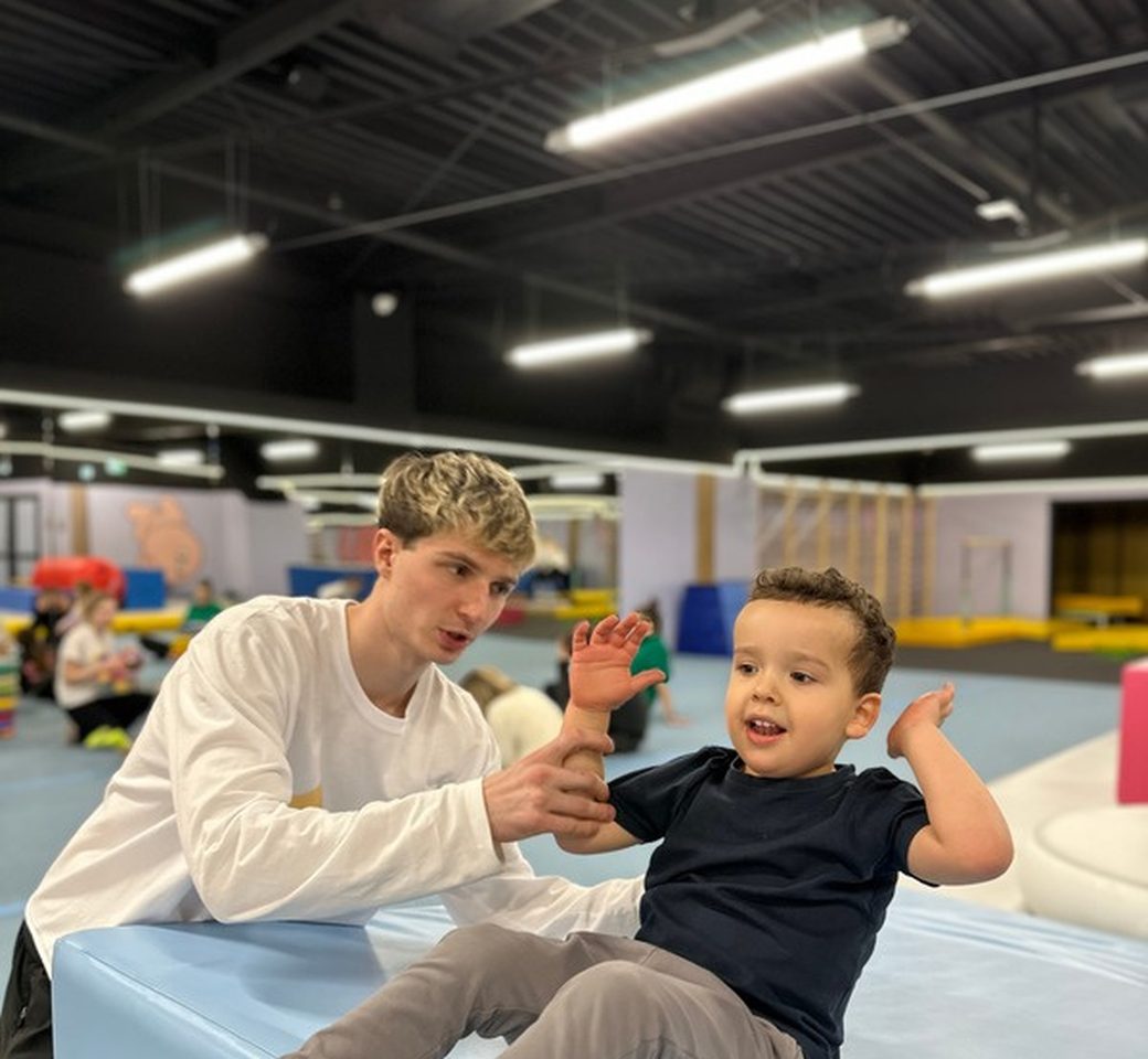 Trener Gymnastic podczas zajęć z dzieckiem